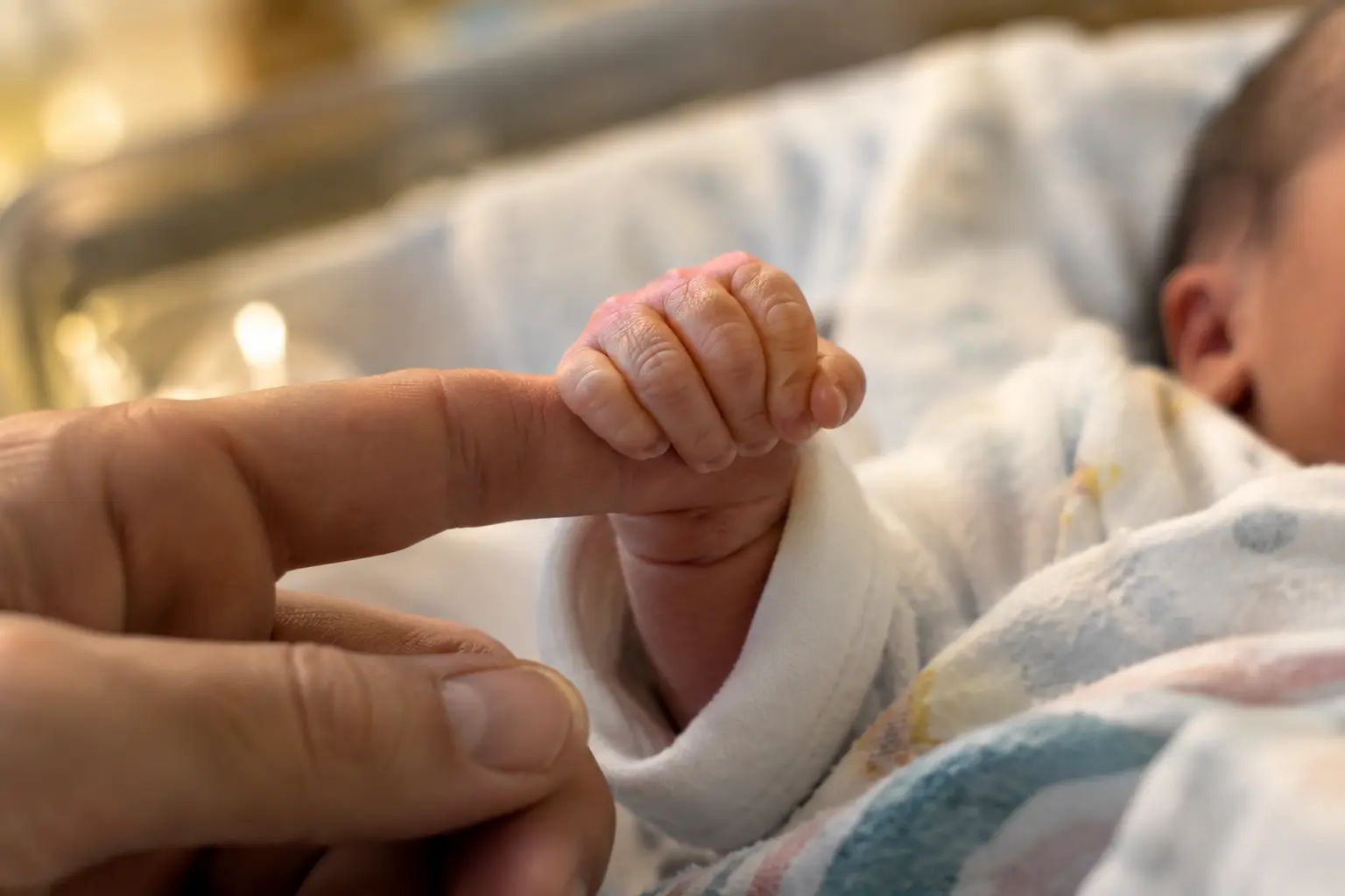 Close-up of a newborn baby's hand, illustrating postnatal care and midwifery